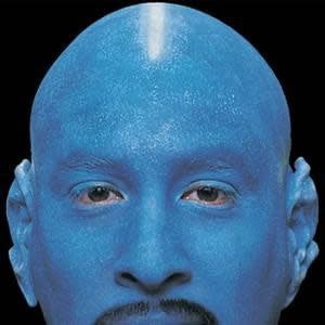 A man in all blue wearing a bald cap for his costume.