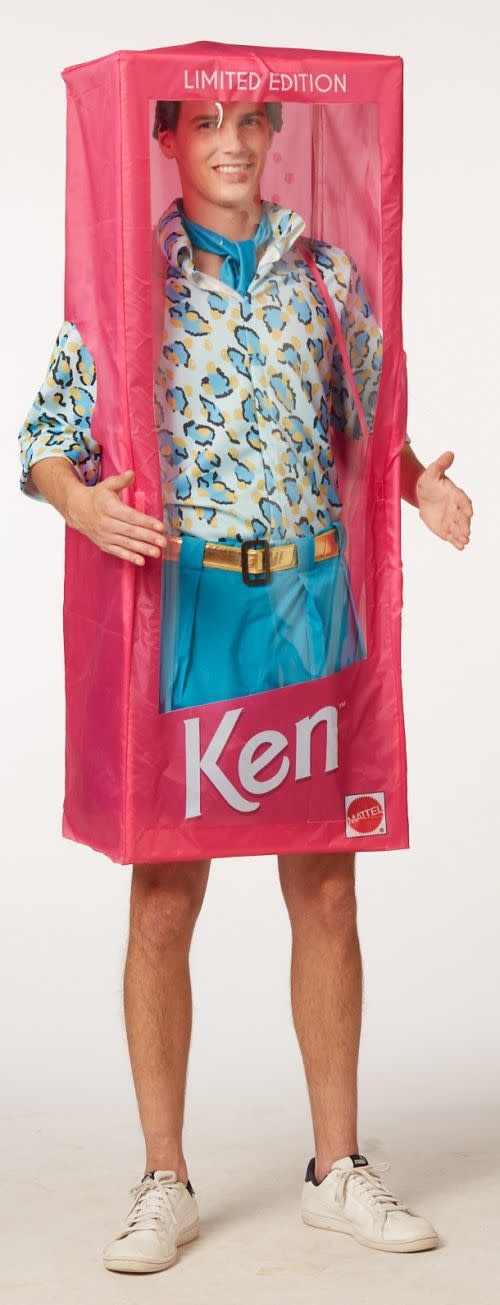 A man wearing a Ken Halloween Costume inside a Barbie box.