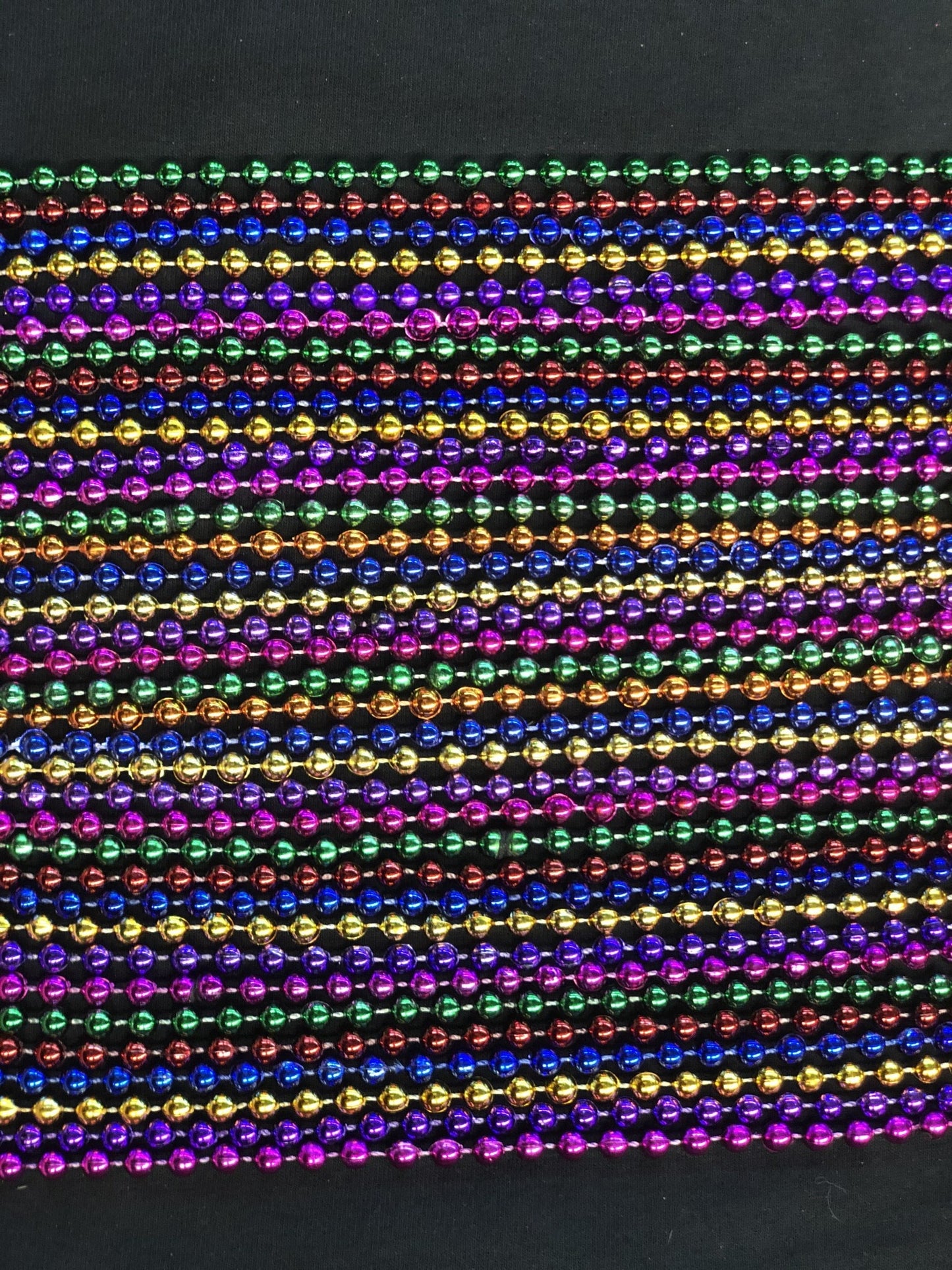An over the top view of different colored beads for Mardi Gras. 